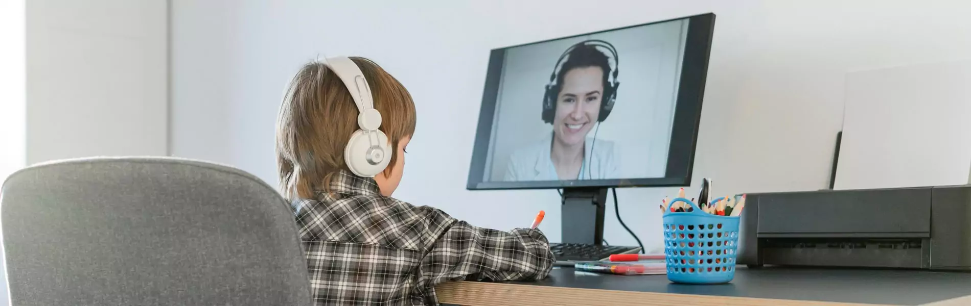 A kid learning through online class on desktop while listening music