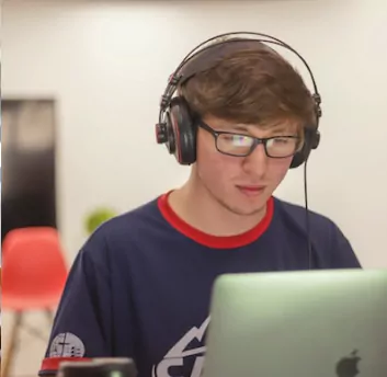 A boy listening lecture on laptop wearing headsets