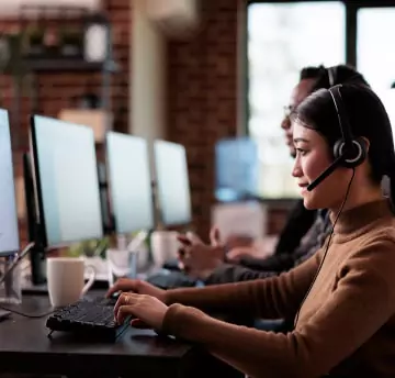 Employees working on desktop wearing headsets