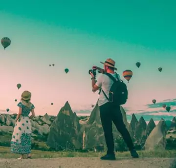 A men taking picture of girl from back at beautiful location